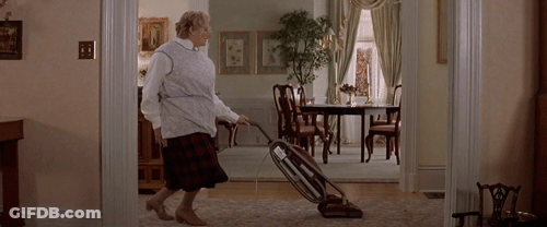 A Woman Is Vacuuming The Floor In A Living Room GIF