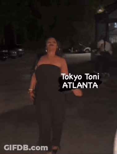 A Woman Is Walking Down A Street With The Words Tokyo Toni Atlanta Written On The Bottom GIF