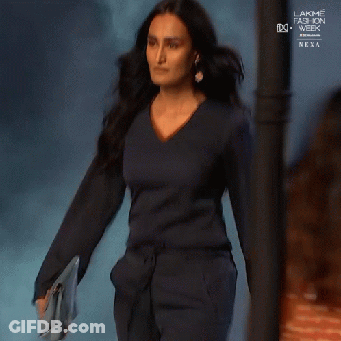 A Woman Is Walking Down The Runway At The Lakme Fashion Week GIF