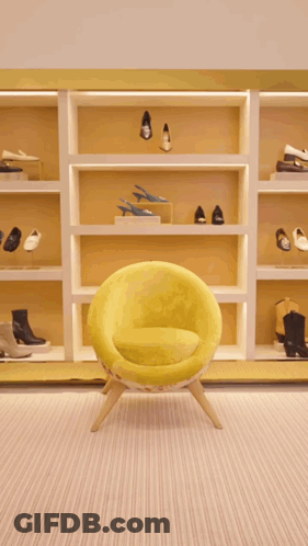 A Woman Is Walking In A Store Holding A Green Purse GIF
