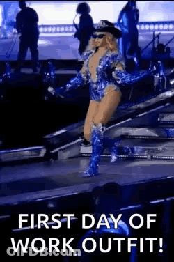 A Woman Is Walking On A Stage Wearing A Police Uniform And Boots . GIF