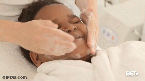 A Woman Is Washing A Child 'S Face And The Bet Logo Is Visible GIF