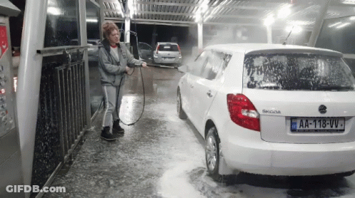 A Woman Is Washing A White Skoda Car With A License Plate That Says Aa-118-Vv GIF