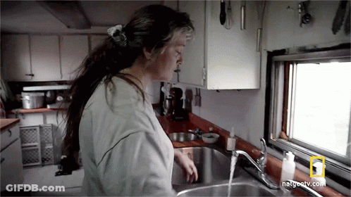 A Woman Is Washing Her Hands In A Kitchen Sink With Natgeotv.com Written On The Bottom GIF