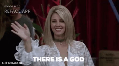 A Woman Is Waving Her Hand And Saying `` There Is A God '' While Standing In Front Of A Red Curtain . GIF