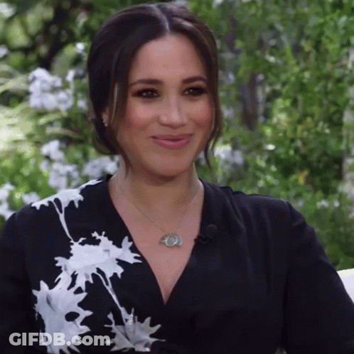 A Woman Is Wearing A Black And White Dress And A Necklace GIF
