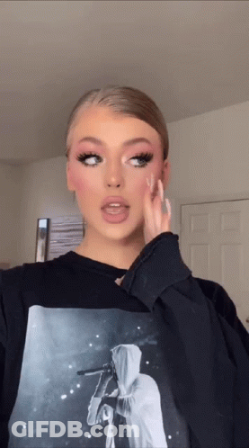 A Woman Is Wearing A Black Sweatshirt With A Picture Of A Person On It GIF