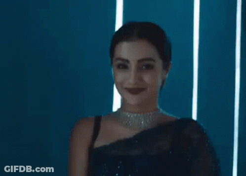 A Woman Is Wearing A Blue Saree And A Diamond Necklace . GIF