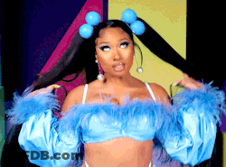 A Woman Is Wearing A Blue Top With Feathers And Pigtails In Her Hair . GIF