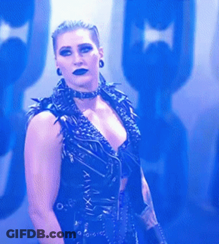 A Woman Is Wearing A Choker And A Black Vest With Roman Numerals On The Front . GIF