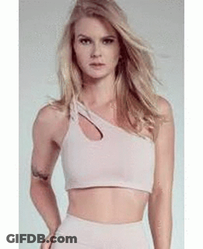 A Woman Is Wearing A Crop Top With A Cut Out On The Side . GIF