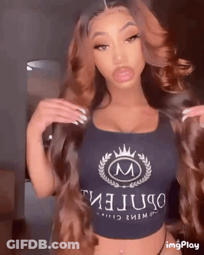 A Woman Is Wearing A Crop Top With The Letter M On It GIF