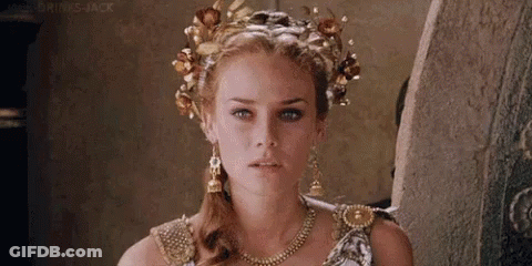 A Woman Is Wearing A Crown Of Flowers On Her Head . GIF