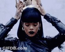 A Woman Is Wearing A Crown On Her Head And Has Black Lipstick . GIF