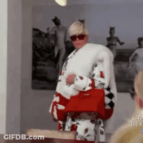 A Woman Is Wearing A Fur Coat And Holding A Red Purse . GIF