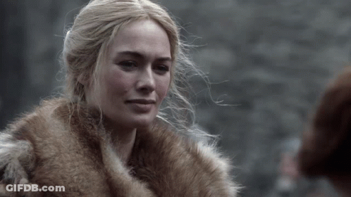 A Woman Is Wearing A Fur Coat And Looking At Something GIF