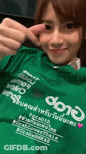 A Woman Is Wearing A Green Shirt That Says Grabth GIF