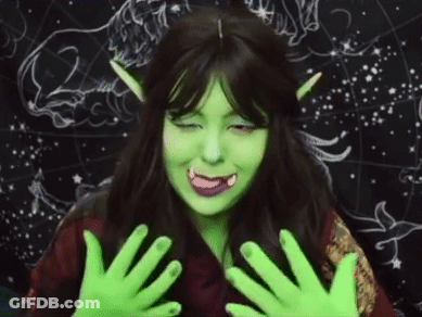 A Woman Is Wearing A Green Wig And Green Gloves . GIF