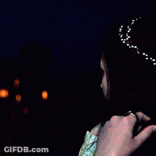 A Woman Is Wearing A Headband With White Beads On It GIF