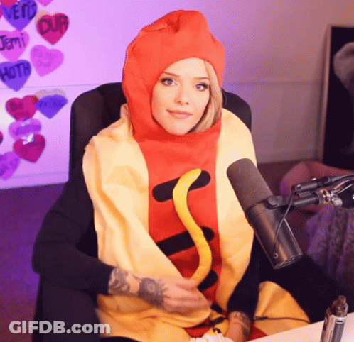 A Woman Is Wearing A Hot Dog Costume And Sitting In Front Of A Microphone GIF