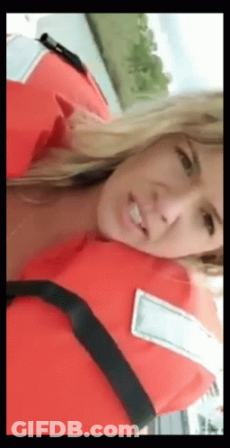 A Woman Is Wearing A Life Jacket And Smiling GIF