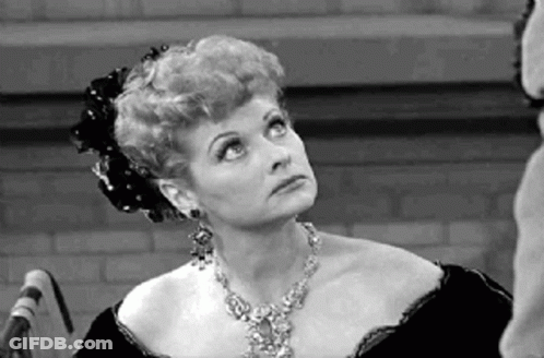 A Woman Is Wearing A Necklace And Earrings And Looking Up . GIF