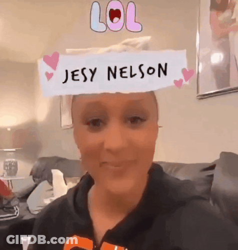 A Woman Is Wearing A Paper That Says Jesy Nelson GIF