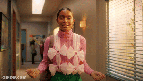 A Woman Is Wearing A Pink Sweater With Bows On It . GIF