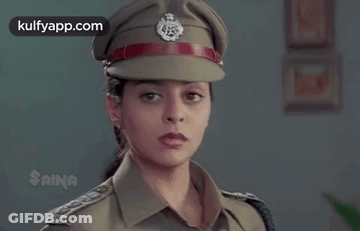 A Woman Is Wearing A Police Uniform And Hat . GIF
