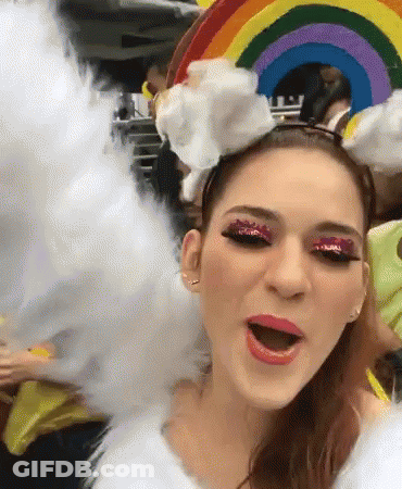 A Woman Is Wearing A Rainbow Headband And Cotton Candy GIF