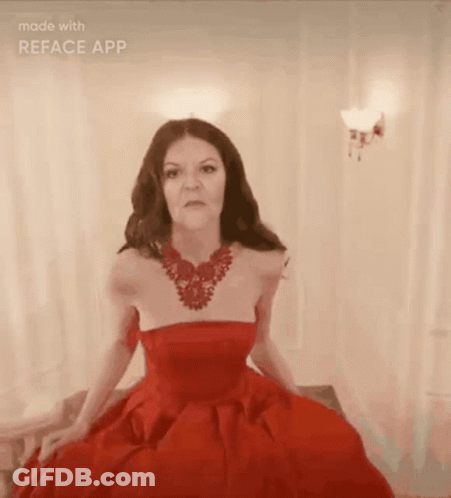 A Woman Is Wearing A Red Dress And A Red Necklace GIF