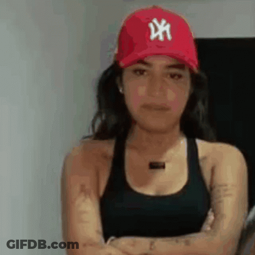 A Woman Is Wearing A Red Hat And A Black Tank Top . GIF