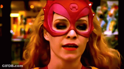 A Woman Is Wearing A Red Mask With A M On It GIF
