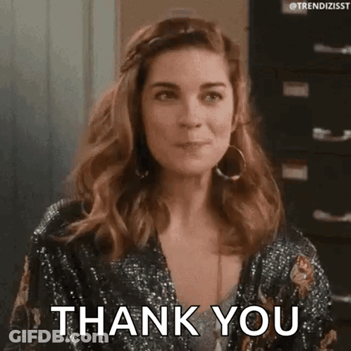 A Woman Is Wearing A Sequined Jacket And Earrings And Saying Thank You . GIF