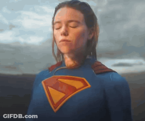 A Woman Is Wearing A Superman Costume With Her Eyes Closed . GIF