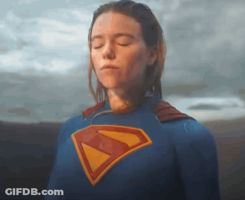 A Woman Is Wearing A Superman Costume With Her Eyes Closed . GIF