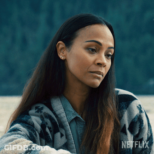 A Woman Is Wearing A Sweater With A Netflix Logo On It GIF