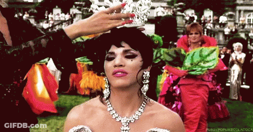A Woman Is Wearing A Tiara And A Necklace GIF