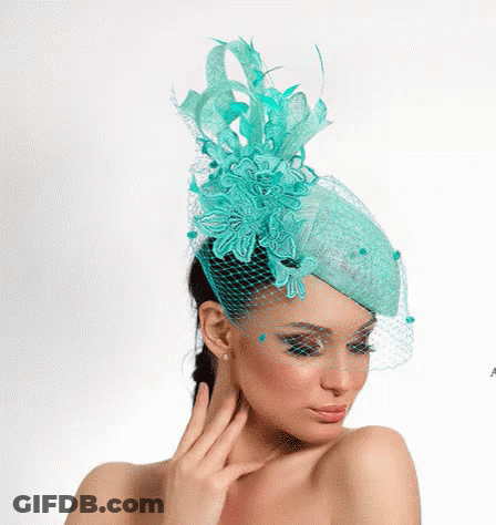 A Woman Is Wearing A Turquoise Hat With A Veil GIF