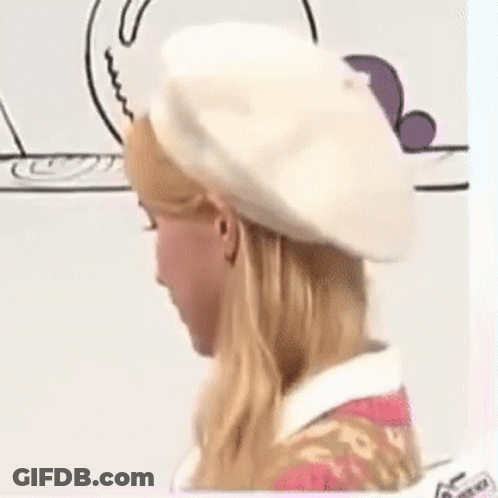 A Woman Is Wearing A White Beret And A Pink Dress . GIF