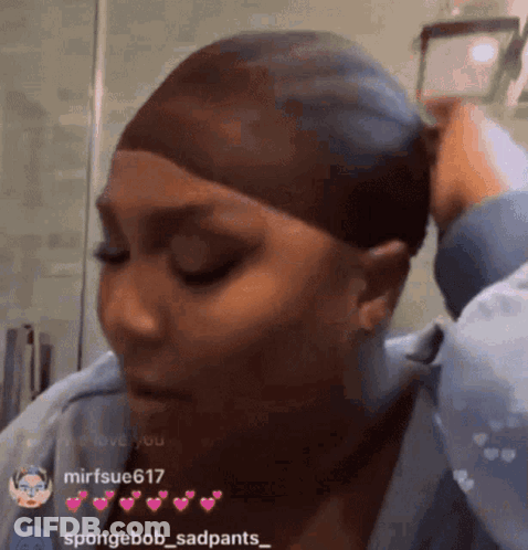 A Woman Is Wearing A Wig And Taking A Picture Of Herself In A Mirror . GIF