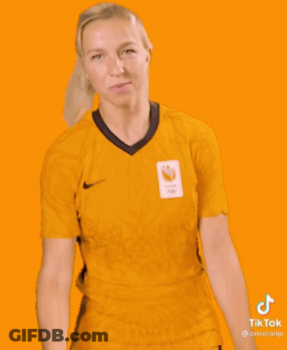 A Woman Is Wearing A Yellow Shirt And Shorts With A Sticker That Says Tiktok GIF