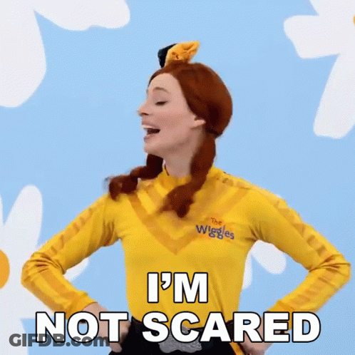 A Woman Is Wearing A Yellow Shirt That Says The Wiggles On It GIF