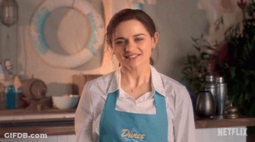 A Woman Is Wearing An Apron That Says Dunes On It GIF
