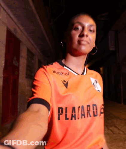 A Woman Is Wearing An Orange Shirt That Says Placard GIF