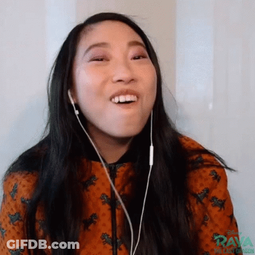 A Woman Is Wearing Headphones And Making A Funny Face While Listening To Music . GIF