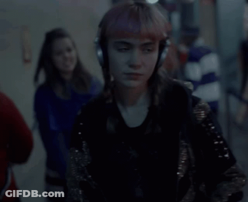 A Woman Is Wearing Headphones And Singing Into A Microphone GIF