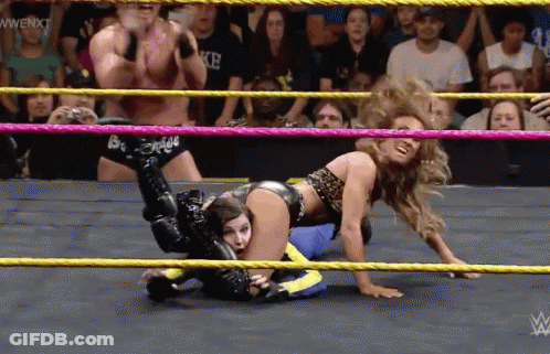 A Woman Is Wrestling A Man In A Wrestling Ring With A Wwe Logo In The Corner GIF