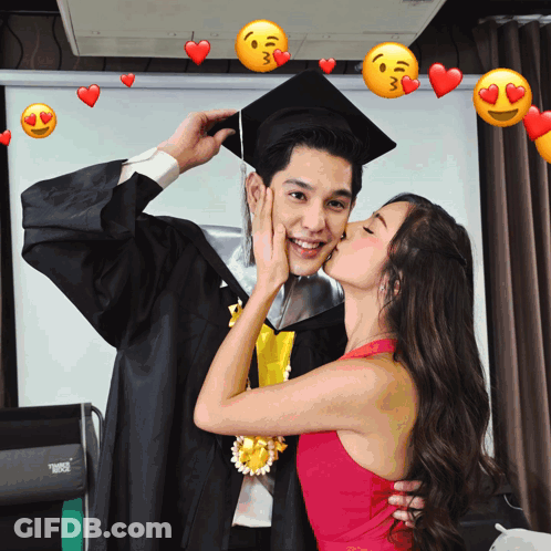 A Woman Kisses A Man In A Graduation Cap And Gown With Hearts Around Them GIF