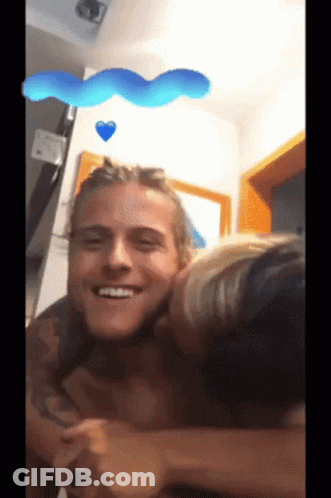 Woman Kissing Man On Cheek In Room GIF